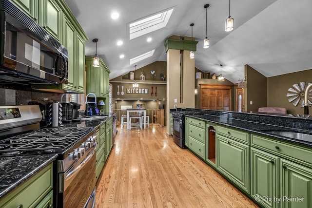 kitchen featuring green cabinets, sink, lofted ceiling with skylight, and black appliances