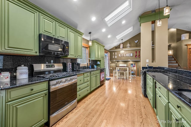 kitchen with tasteful backsplash, green cabinets, gas range, and pendant lighting