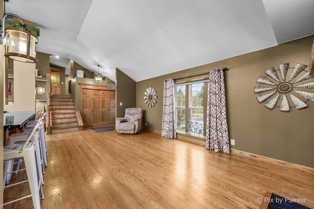 living room featuring lofted ceiling and light hardwood / wood-style floors