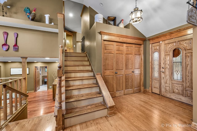 entryway featuring light hardwood / wood-style flooring, an inviting chandelier, and vaulted ceiling