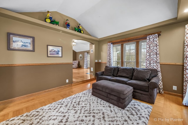 living room with light wood-type flooring and vaulted ceiling