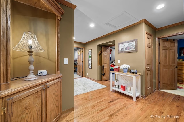 corridor featuring ornamental molding and light hardwood / wood-style flooring