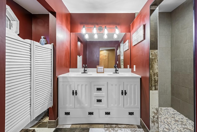 bathroom featuring tiled shower and vanity