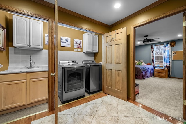 washroom with washer and dryer, cabinets, sink, and light wood-type flooring