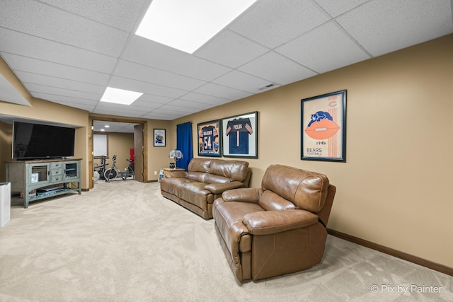 living room featuring carpet flooring and a drop ceiling