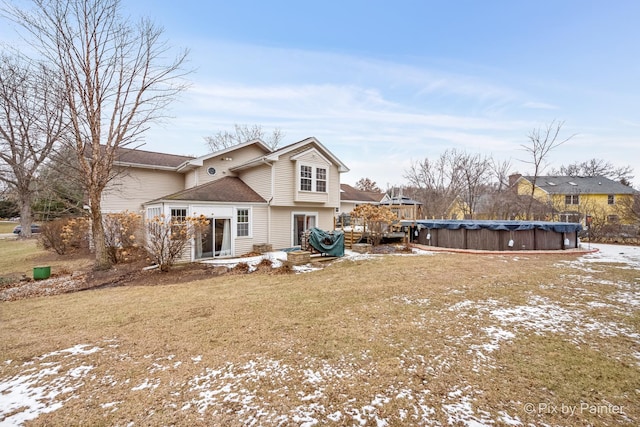 snow covered property with a covered pool and a lawn