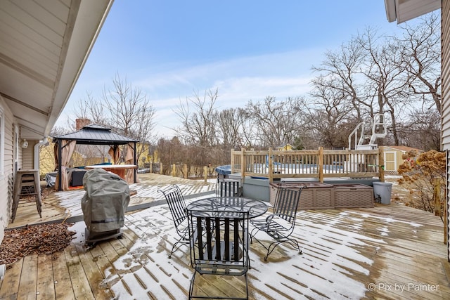 snow covered deck with a gazebo and a hot tub