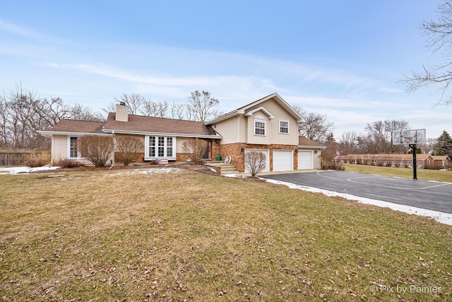 tri-level home featuring a front lawn and a garage