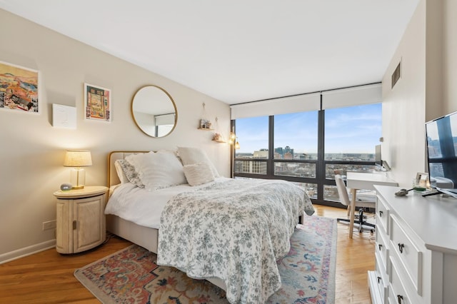 bedroom featuring light hardwood / wood-style floors and expansive windows