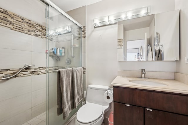 bathroom featuring vanity, an enclosed shower, and toilet