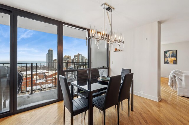 dining space with a notable chandelier, plenty of natural light, and light wood-type flooring