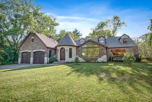 french country home featuring a front yard and a garage