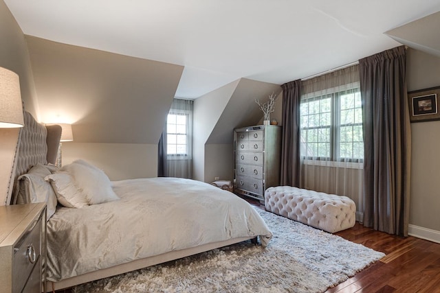 bedroom with multiple windows, dark hardwood / wood-style floors, and lofted ceiling