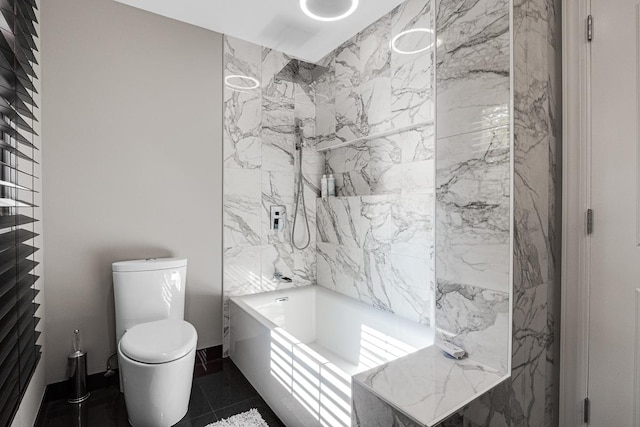 bathroom featuring toilet, tiled shower / bath, and tile patterned floors