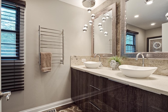 bathroom with decorative backsplash, radiator heating unit, and vanity