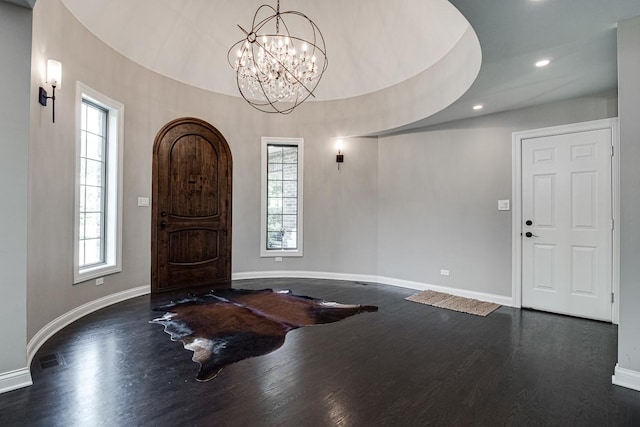 foyer entrance with dark wood-type flooring and a notable chandelier