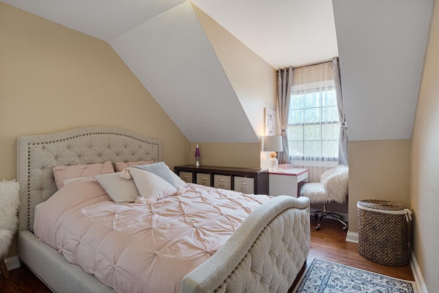 bedroom with dark wood-type flooring and lofted ceiling