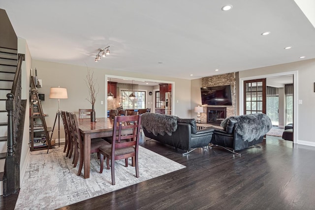 dining space with a fireplace, a wealth of natural light, and dark hardwood / wood-style flooring