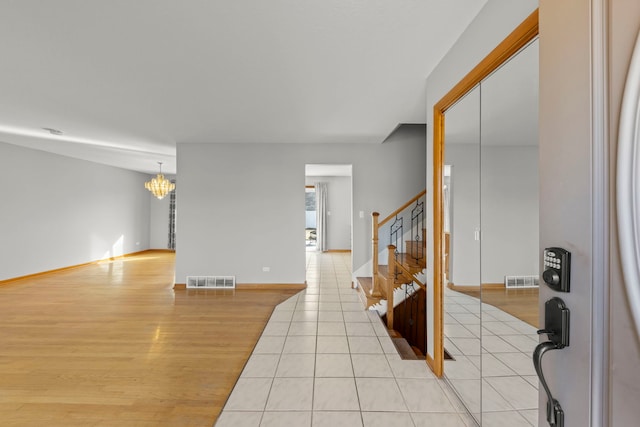 interior space with light wood finished floors, baseboards, stairs, and visible vents