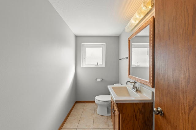 bathroom with toilet, tile patterned flooring, baseboards, and vanity