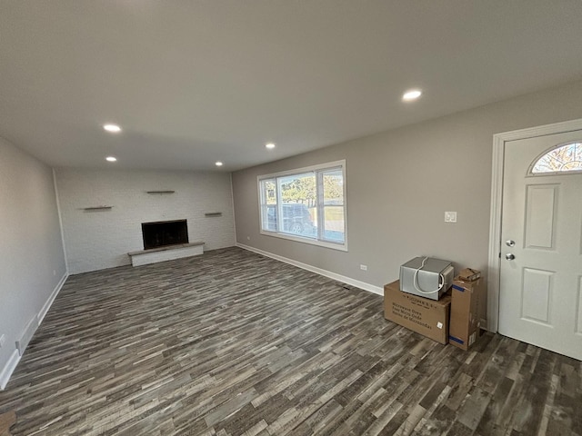 unfurnished living room with dark wood-type flooring