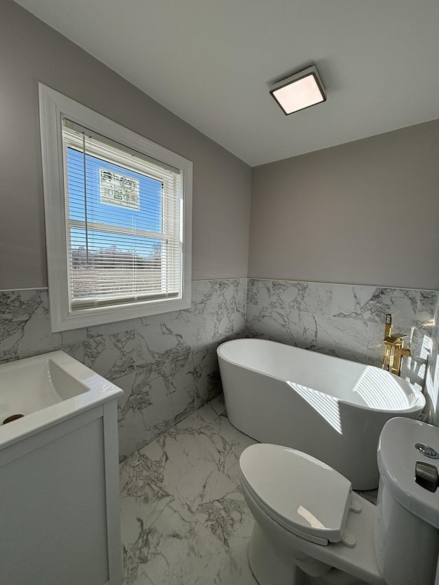 bathroom with vanity, a washtub, tile walls, and toilet