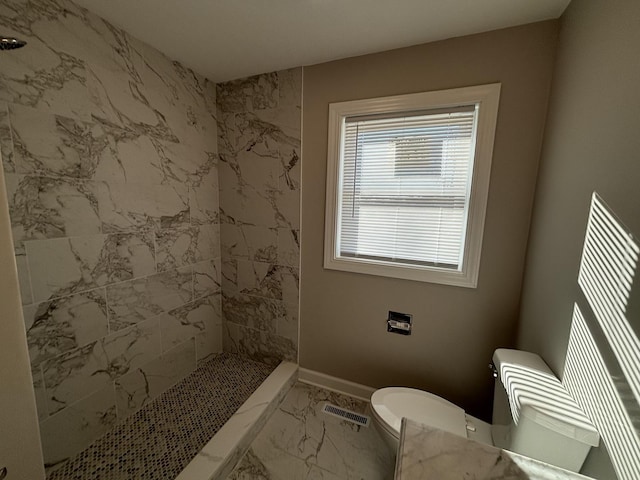 bathroom with toilet and tiled shower