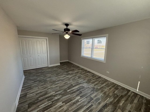 unfurnished bedroom with ceiling fan, dark hardwood / wood-style floors, and a closet