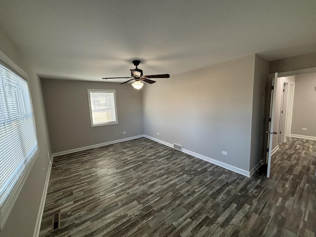 spare room featuring dark wood-type flooring and ceiling fan