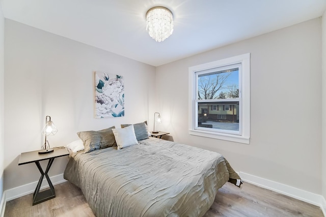 bedroom with a chandelier and light hardwood / wood-style flooring