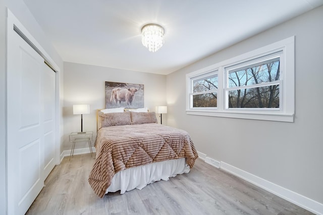 bedroom featuring a chandelier and light hardwood / wood-style flooring