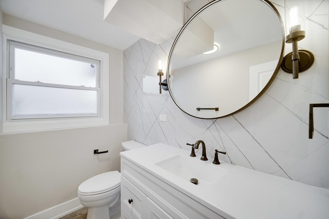 bathroom with toilet, vanity, and tasteful backsplash