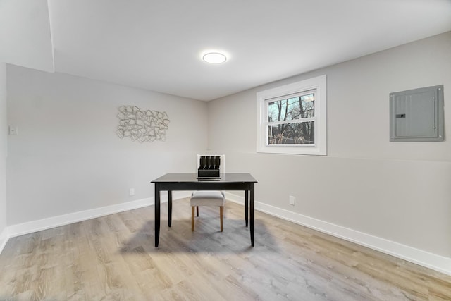 office area with light wood-type flooring and electric panel