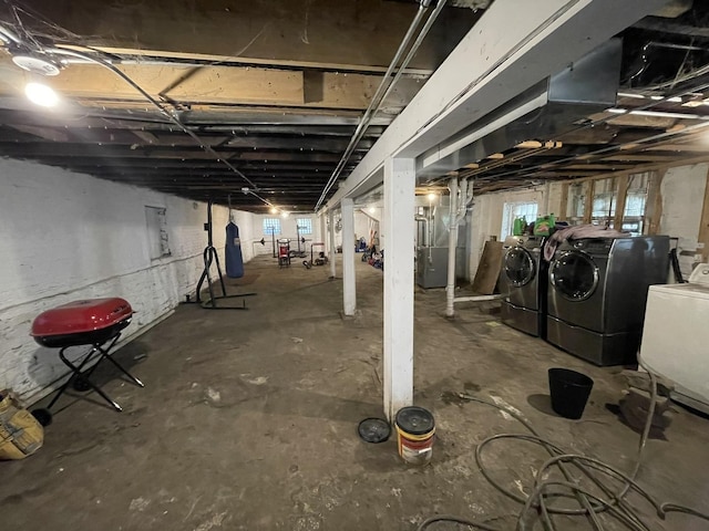 basement with electric panel, a healthy amount of sunlight, and washing machine and clothes dryer