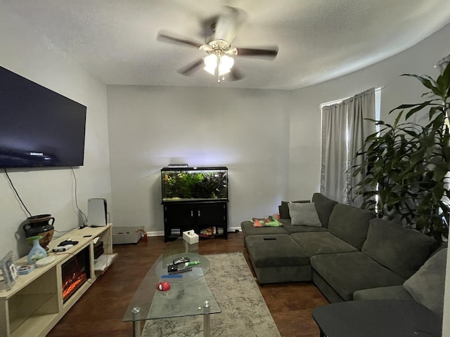 living room with ceiling fan, a textured ceiling, and dark hardwood / wood-style flooring