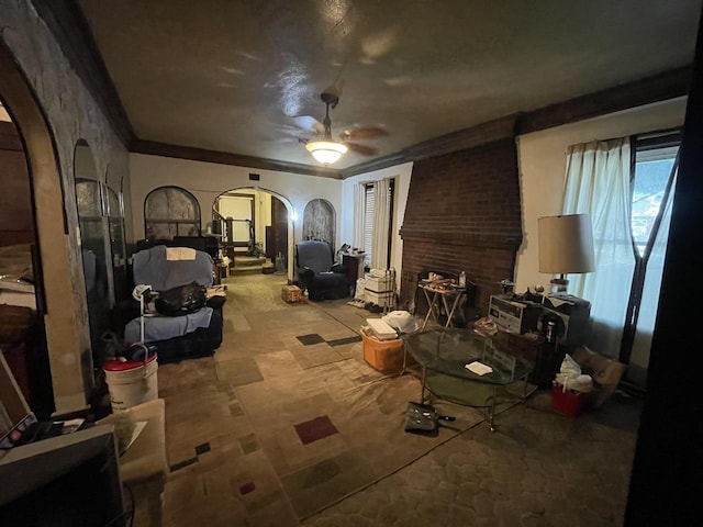 living room with ceiling fan and crown molding