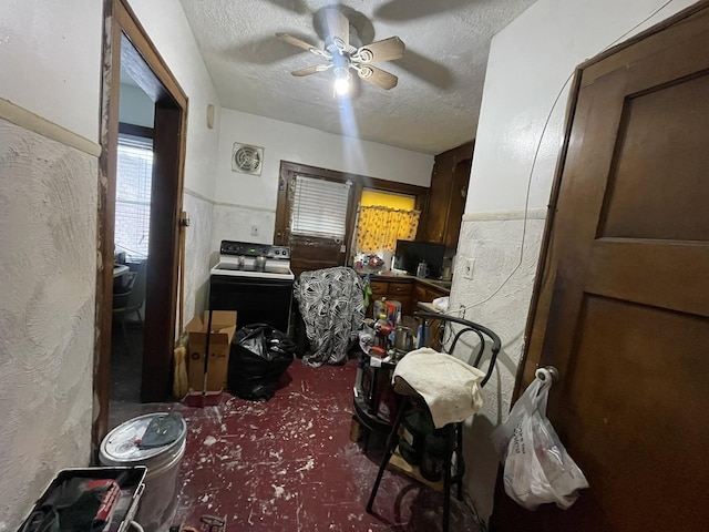 miscellaneous room with a textured ceiling, ceiling fan, and washer / clothes dryer