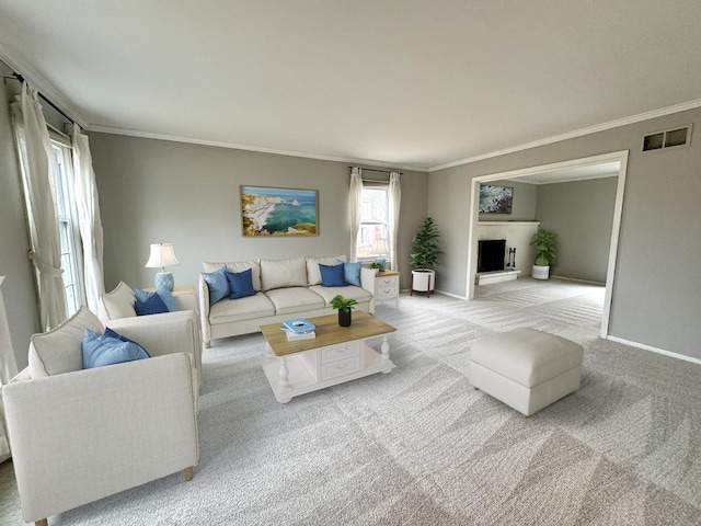 living room featuring ornamental molding, a fireplace, baseboards, and light carpet