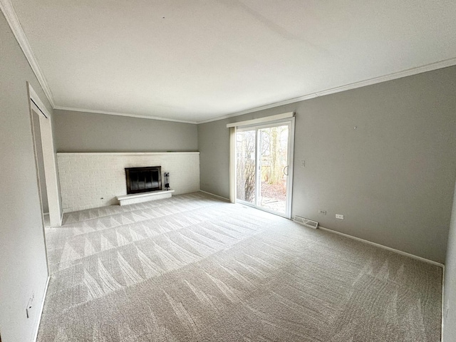 unfurnished living room featuring visible vents, a fireplace with raised hearth, carpet, crown molding, and baseboards