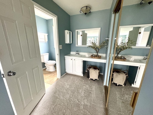 bathroom with baseboards, toilet, and vanity