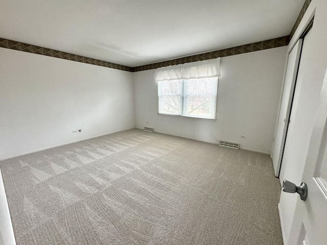 spare room with visible vents and carpet floors