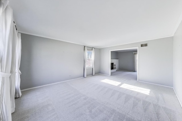 unfurnished bedroom featuring visible vents, light carpet, baseboards, and crown molding