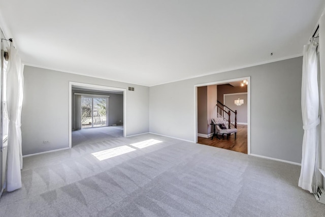 carpeted spare room featuring stairway, visible vents, baseboards, and ornamental molding