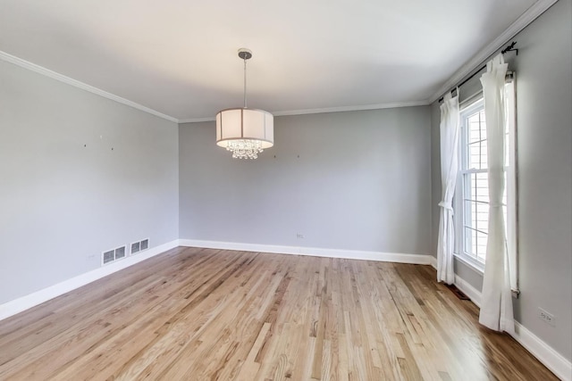 unfurnished room featuring baseboards, an inviting chandelier, wood finished floors, and crown molding