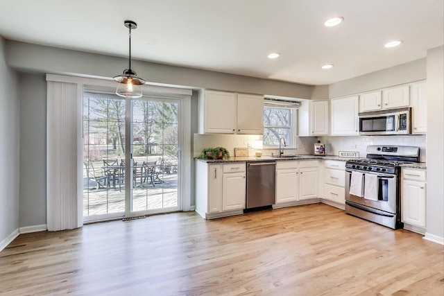 kitchen with dark stone counters, white cabinets, and stainless steel appliances