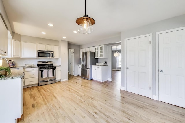 kitchen featuring recessed lighting, stainless steel appliances, white cabinetry, and light wood finished floors