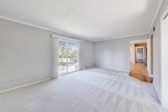 spare room with visible vents, baseboards, light colored carpet, and crown molding