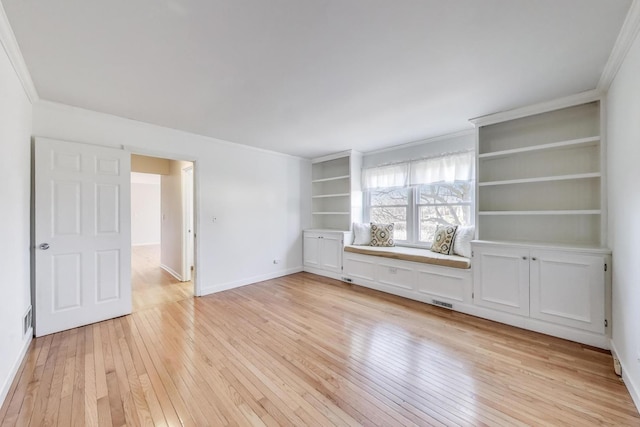 interior space with crown molding, visible vents, baseboards, and light wood finished floors