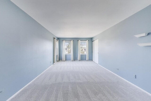 empty room featuring baseboards and carpet floors