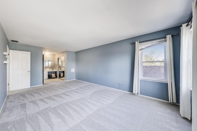 unfurnished living room featuring carpet flooring, baseboards, and visible vents